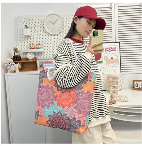 Gedetailleerd overzicht van grote canvas tote bag met kleurrijke mandalaprint en touwgrepen.