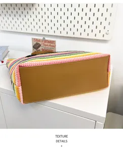 Λεπτομερής όψη της χρωματιστής πλεχτής ψάθινης τσάντας με καφέ δερμάτινο πάτο για καλοκαίρι.