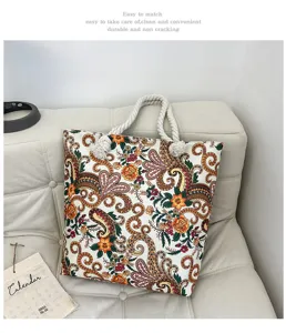 Dettaglio della borsa shopper in tela con motivo floreale bohémien e manici in corda spessa.
