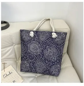 Dettaglio della borsa shopper in tela boho con intricati motivi cachemire bianchi e manici in corda.