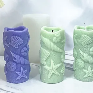 Gros plan de bougies parfumées cylindriques marines avec de délicats reliefs de coquillages et d'étoiles.