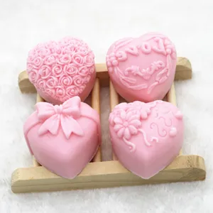 Gros plan de quatre moules en silicone rose en forme de cœur avec des motifs gaufrés.