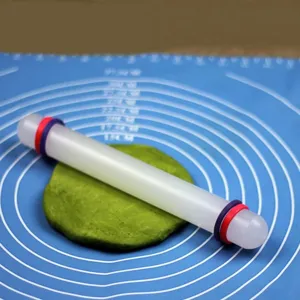 Vue détaillée d'un rouleau à pâtisserie en plastique blanc avec anneaux sur tapis bleu.