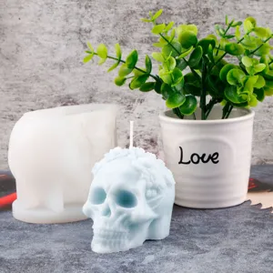 Detailed shot of 3D skull scented candle and silicone mold with floral pattern for DIY craft.