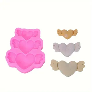 Silicone heart wings mold detail showing pink mold and three finished angel wing decors.
