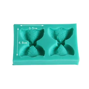 Detail view of the green silicone bow mold showing accurate dimensions for baking and clay crafts.