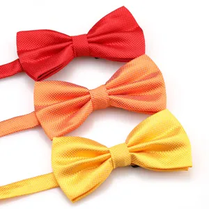 Detailed view of colorful grid bow ties in red, orange, and yellow for formal events and weddings.
