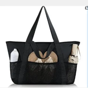 Detail view of the black mesh beach bag featuring multiple front pockets and sturdy tote handles.