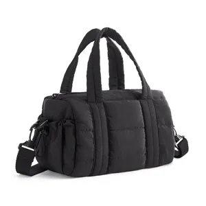Close-up detail of black quilted nylon puffer shoulder bag with convenient handles.