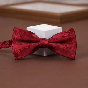 Wine red patterned bow tie detail shot, elegant fabric for men suits, weddings, and formal wear.
