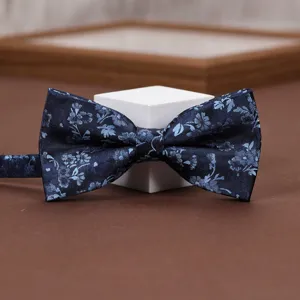 Detail showcase of navy blue floral jacquard bow tie featuring elegant vintage pattern.