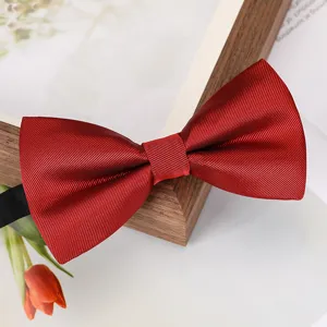 Nœud papillon rouge vin gros plan, tissu texturé de qualité, détail accessoire mariage.