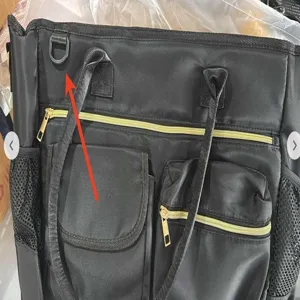 Black nylon laptop bag detail view, multi-pocket design with gold zippers for women