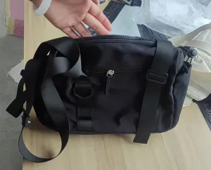 Black nylon messenger bag with front zipper pocket and adjustable straps for casual daily use.