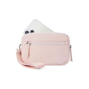 Nahaufnahme einer rosafarbenen gesteppten Handgelenktasche mit Reißverschluss und Handschlaufe.