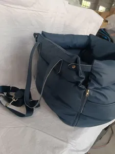 Vue de détail du siège auto et sac de transport pour animal en cuir bleu foncé avec sangle.