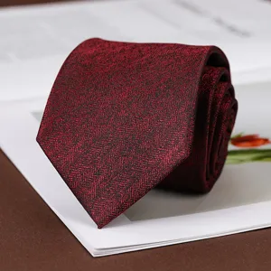 Cravatta bordeaux con motivo spina di pesce, dettaglio in tessuto per abito elegante.