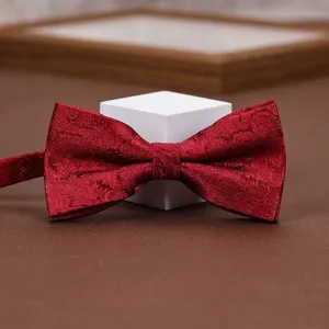 Close-up view of the classic red paisley patterned fabric bow tie showing fine texture.