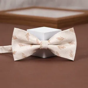 Detailed view of elegant beige bow tie with brown leaf pattern for men's formal wear weddings.
