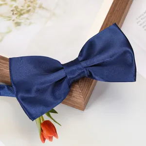 Gros plan détaillé d'un nœud papillon en satin bleu classique, texture lisse et élégante.
