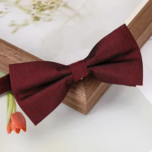 Détail en gros plan d'un nœud papillon chevron rouge foncé élégamment présenté avec du bois.