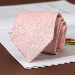 Primo piano dettagliato di una cravate rosa a spina di pesce su sfondo di rivista.