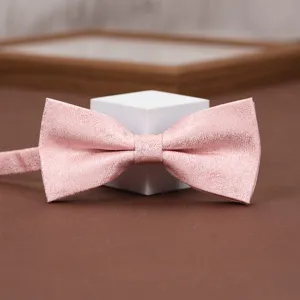 Close-up detail shot of a pink patterned bow tie with fine textured fabric on display stand.