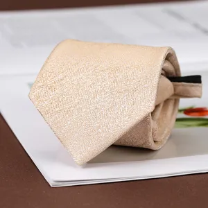 Cravatta con zip preannodata testurizzata in oro champagne, dettaglio da lavoro.