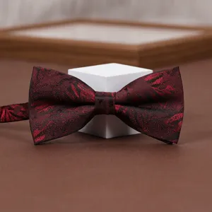 Burgundy bow tie detail shot, elegant jacquard pattern, perfect wedding groom accessory.