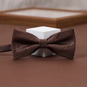 Dettaglio papillon a righe marroni, elegante accessorio retrò per abiti da uomo formali.