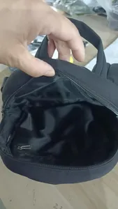 Dettaglio interno dello zaino nero con tasca con cerniera e fodera resistente.
