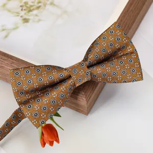 Vue rapprochée de l'élégant nœud papillon à motif doré avec texture de tissu.