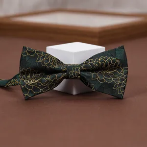 Close-up of elegant dark green bow tie featuring intricate gold floral and stripe jacquard.