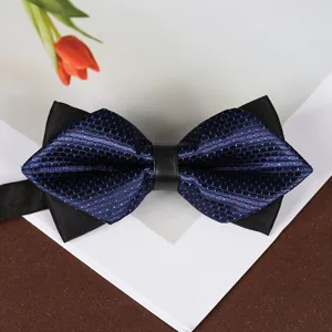 Primo piano del papillon a punta blu scuro con pois, che mostra la trama del tessuto.
