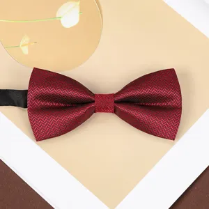 Close-up detail of the wine red herringbone bow tie showing delicate fabric texture and form.