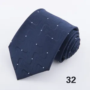 Close-up detail view of a dark blue men's necktie featuring wave patterns and white dots.