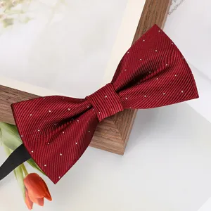 Gros plan d'un noeud papillon bordeaux à pois fins, accessoire de mariage élégant.