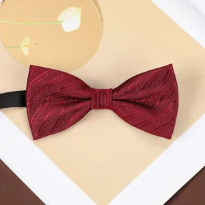 Wine red silk bow tie detail shot, classic textured wedding suit accessory for men and groom.