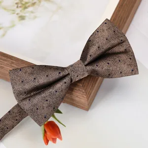 Detailed shot of a brown polka dot bow tie with fine texture and structured shape.