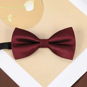 Wine red bow tie detail view, elegant fabric texture for wedding and formal suit wear.