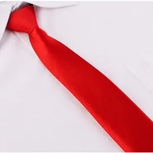 Primo piano di una cravatta stretta rosso vivo presentata su una camicia bianca pulita.