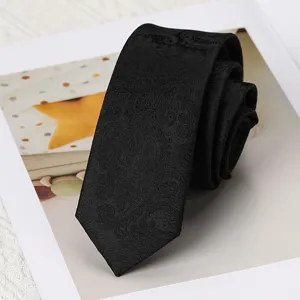 Primer plano de corbata negra con estampado paisley y textura tejida fina, vista detallada elegante.
