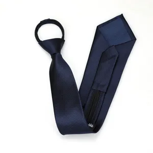 Detalle de la corbata con cremallera azul marino que muestra la tela de sarga texturizada.