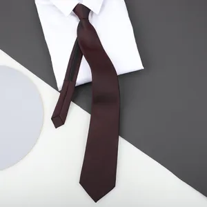 Detail shot of a burgundy zipper tie paired with a crisp white shirt collar for formal wear.