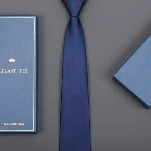 Close-up detail of dark blue textured formal necktie presented with elegant gift box packaging.