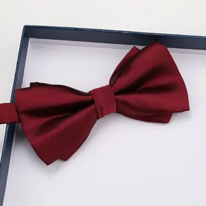 Close-up detail of a burgundy textured bow tie in a gift box, elegant formal wear accessory.