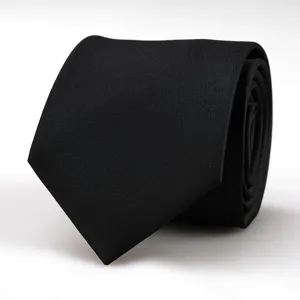 Close-up view of a classic black formal business tie rolled up neatly on clean white background.