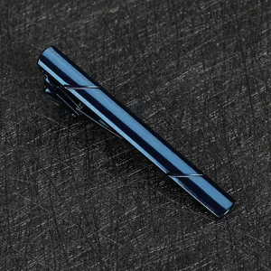 Gros plan detail d'une pince a cravate metallique bleu fonce au design minimaliste elegant.