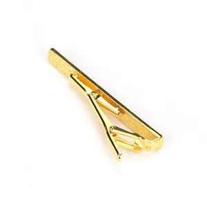 Pince à cravate en laiton plaqué or détail, accessoire élégant pour costume homme.