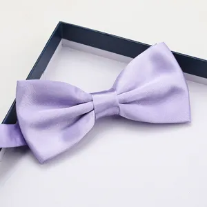 Close-up detail of a elegant lavender satin bow tie neatly placed inside a gift box.